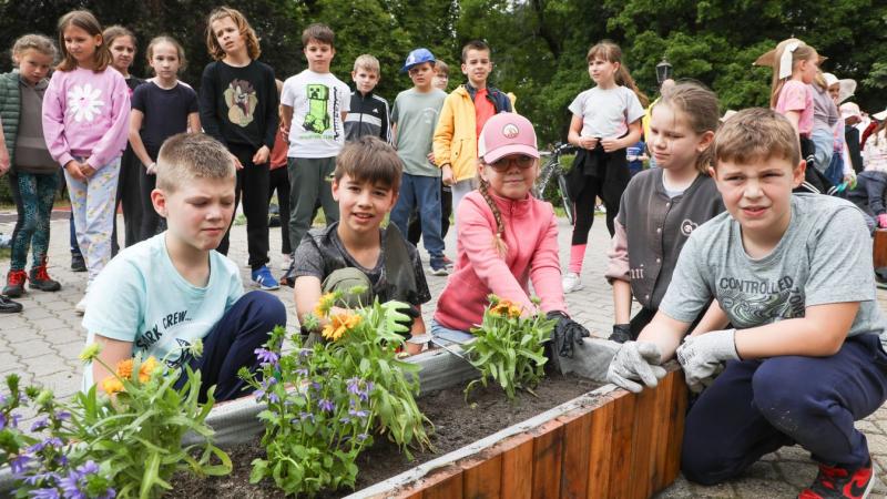 Kisiskolás gyerekek varázsoltak színeket a Népkertbe, amikor virágokat ültettek a napfényes reggelen.